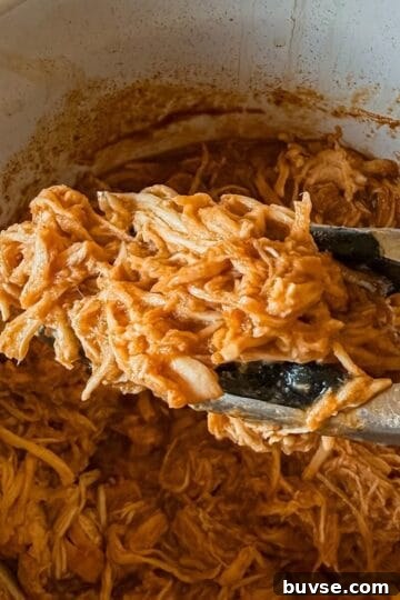 A close up of shredded chicken with bbq sauce made in the crockpot.
