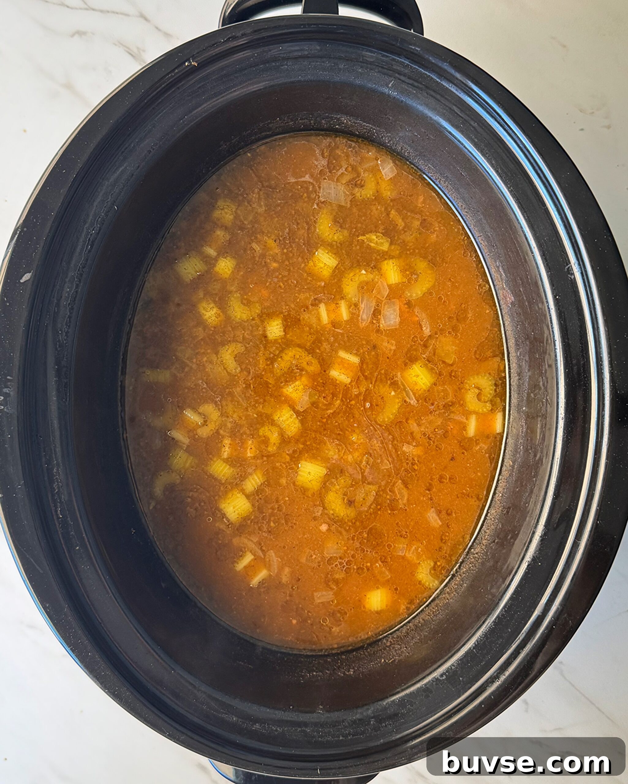 Slow Cooker Beef and Pumpkin Orzo Soup 4 overhead shot of uncooked Beef Pumpkin Orzo Soup in a black slow cooker