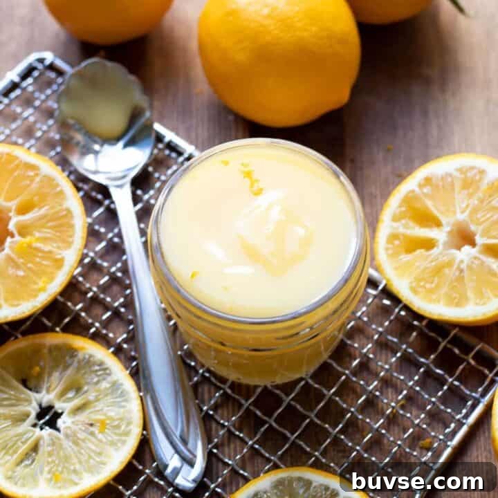 lemon curd in a jar with lemon slices around it