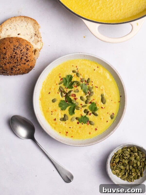 cauliflower soup served with bread rolls and pumpkin seeds.