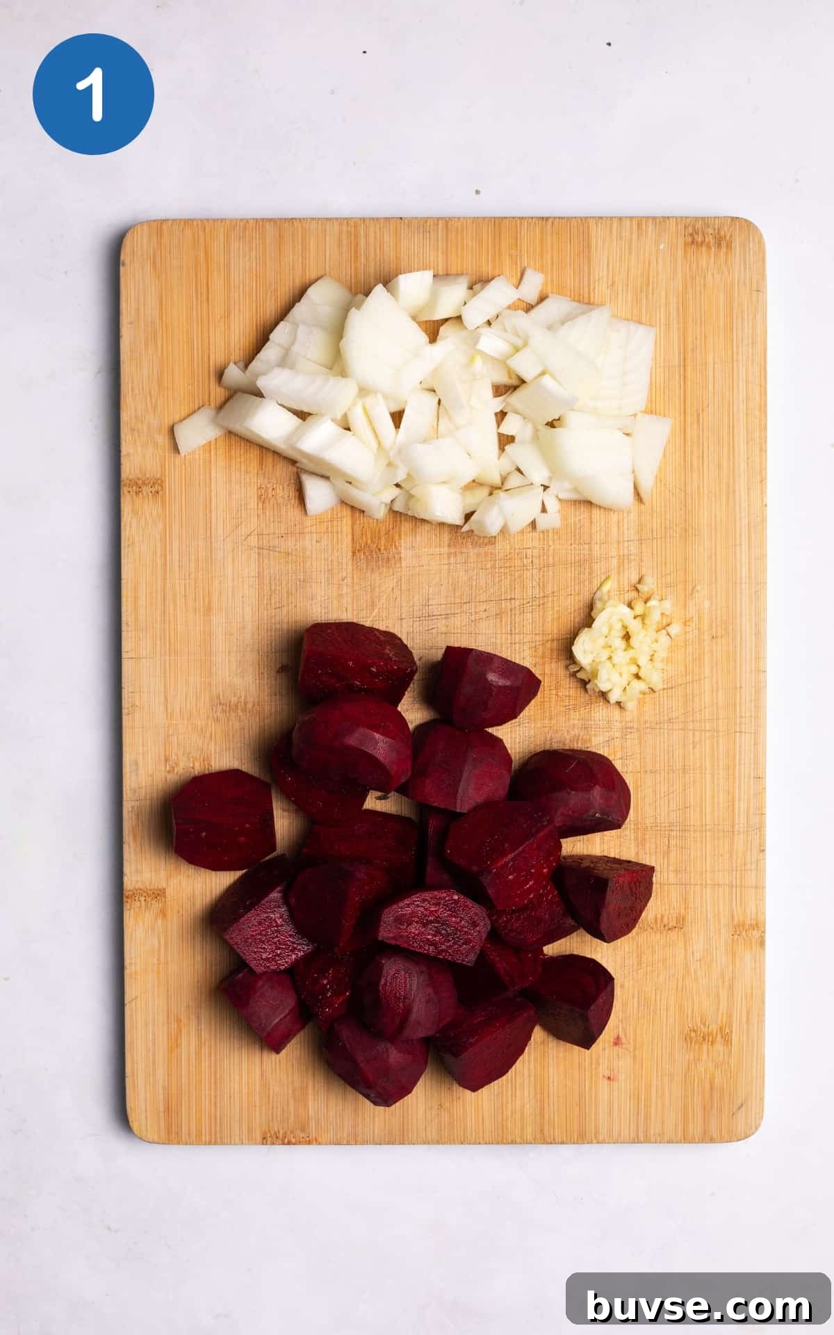 onion, garlic and beetroots on a wooden cutting board.