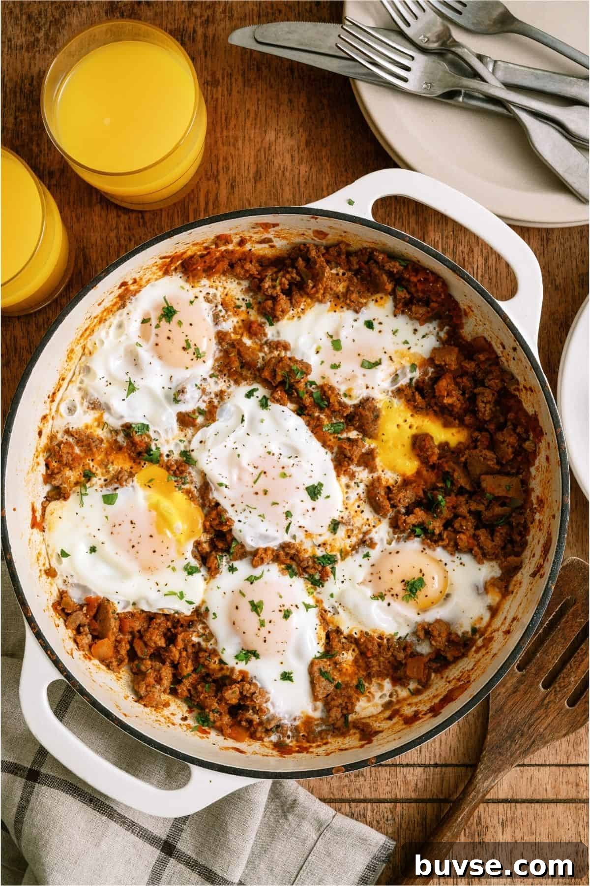 Top view of One Pan Egg and Turkey Skillet in the skillet with two glasses of orange juice on the side.