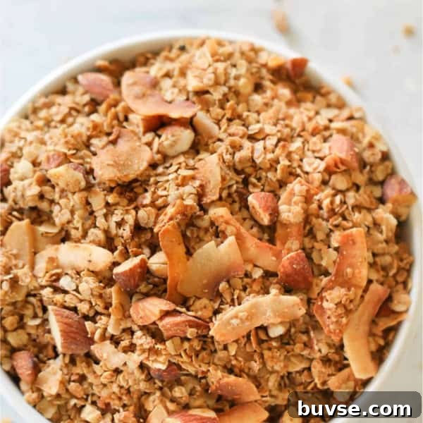 A large white bowl sitting on a counter filled to the top with Almond Butter Granola.