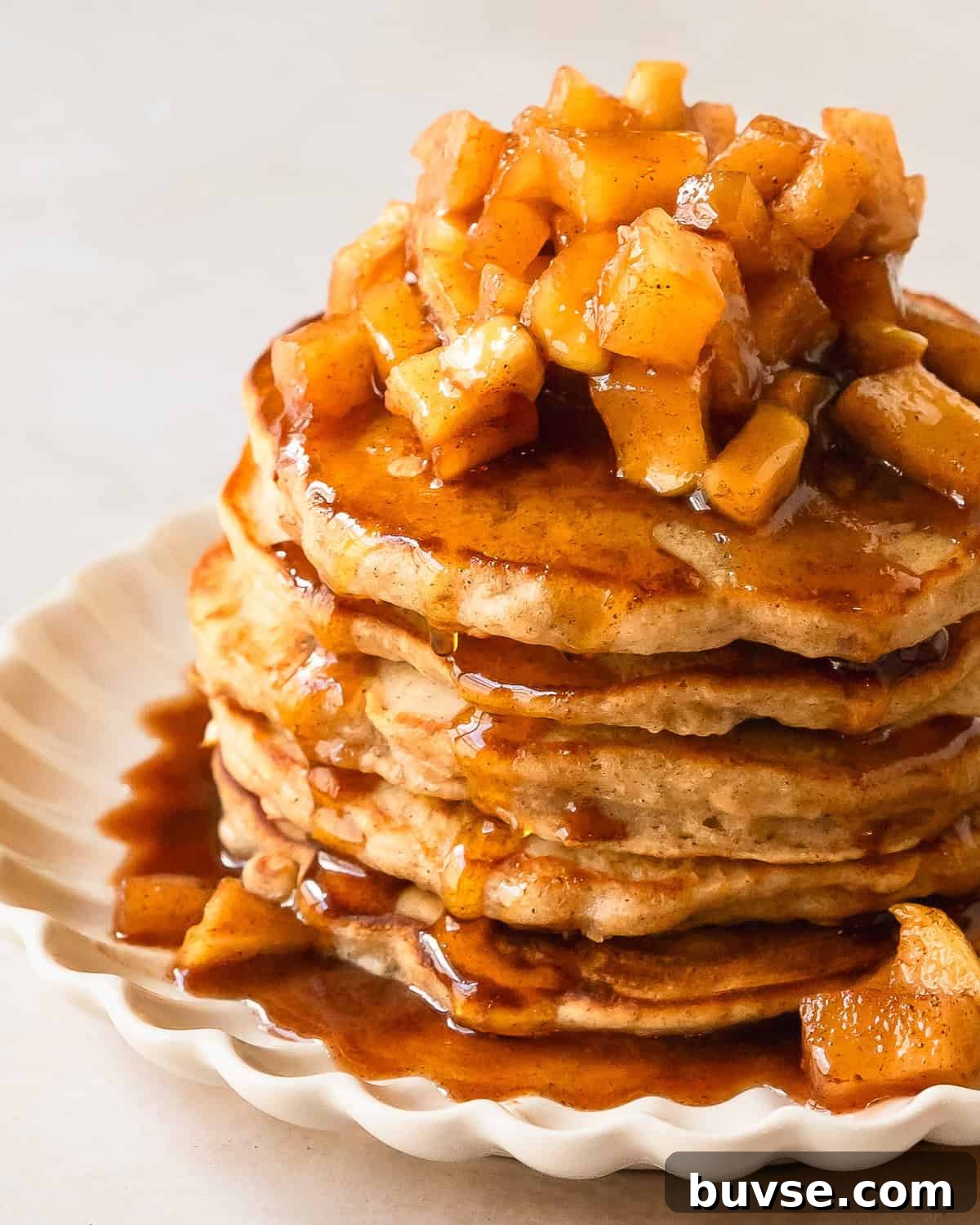 Apple cinnamon pancakes are light and fluffy pancakes made with tart grated apples. Top these melt in your mouth apple pancakes with an easy to make maple glazed, cinnamon spiced apple topping. These cinnamon apple pancakes make the best pancakes for a cozy and indulgent fall breakfast everyone will love.