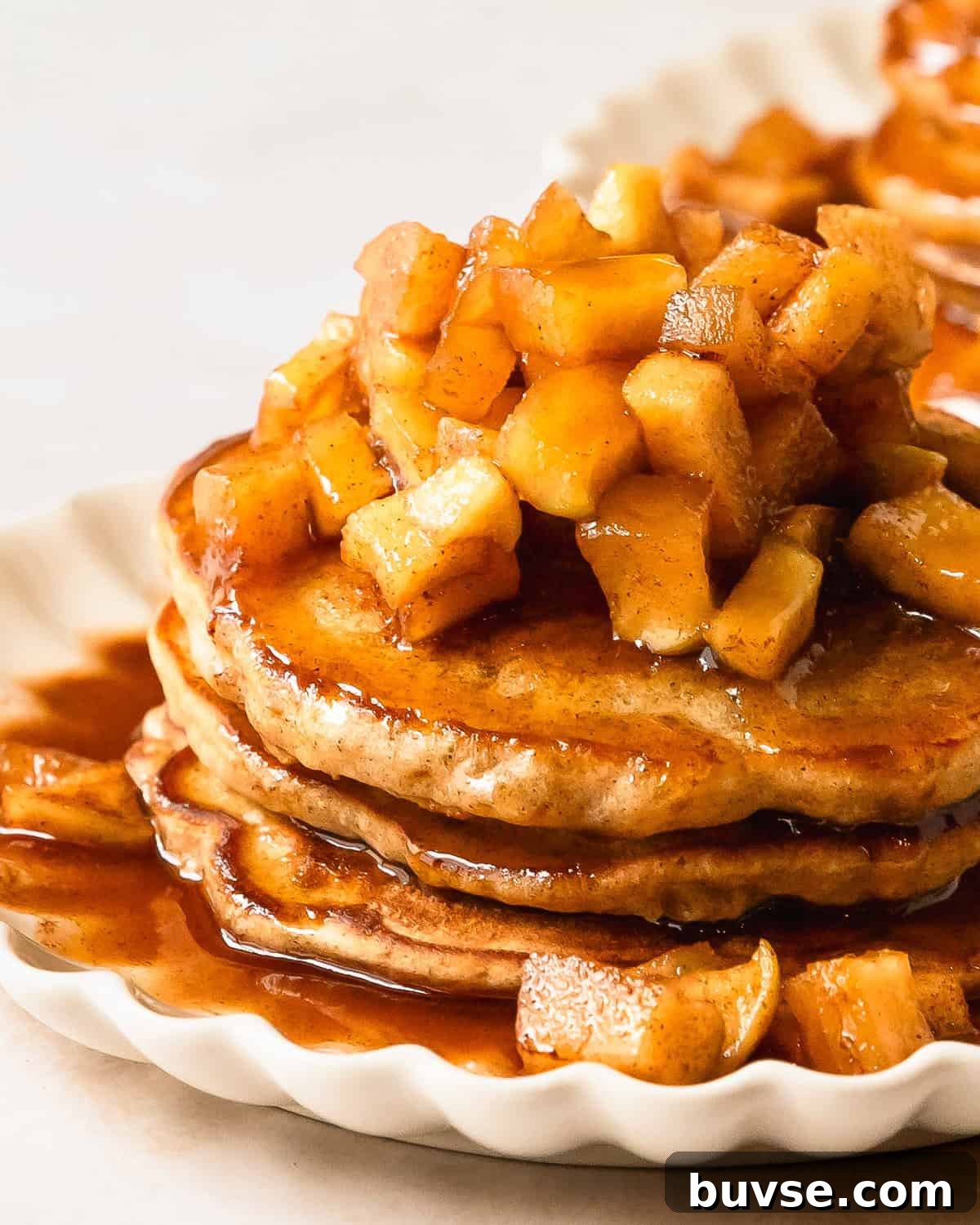 Apple cinnamon pancakes are light and fluffy pancakes made with tart grated apples. Top these melt in your mouth apple pancakes with an easy to make maple glazed, cinnamon spiced apple topping. These cinnamon apple pancakes make the best pancakes for a cozy and indulgent fall breakfast everyone will love.