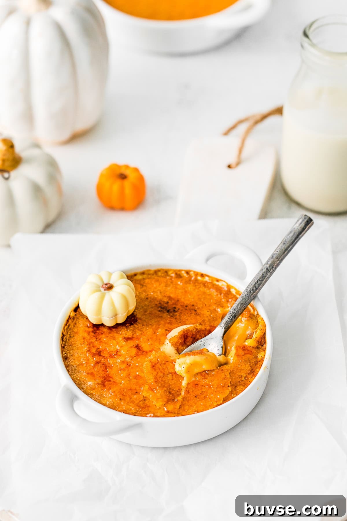 Silky Pumpkin Crème Brûlée Recipe 4 A spoon cracking the sugar topping on a Pumpkin Creme Brulee.