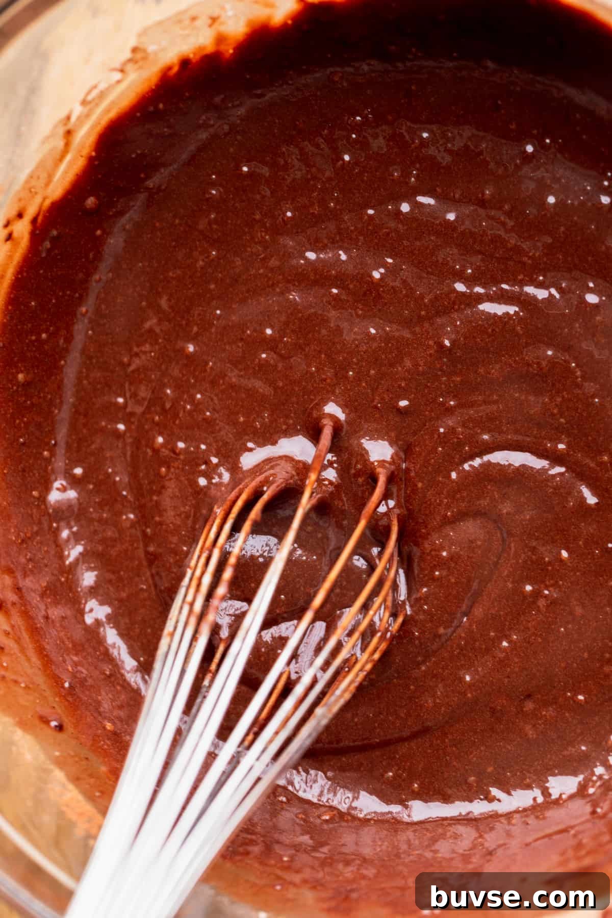 Chocolate cake batter in a glass bowl.