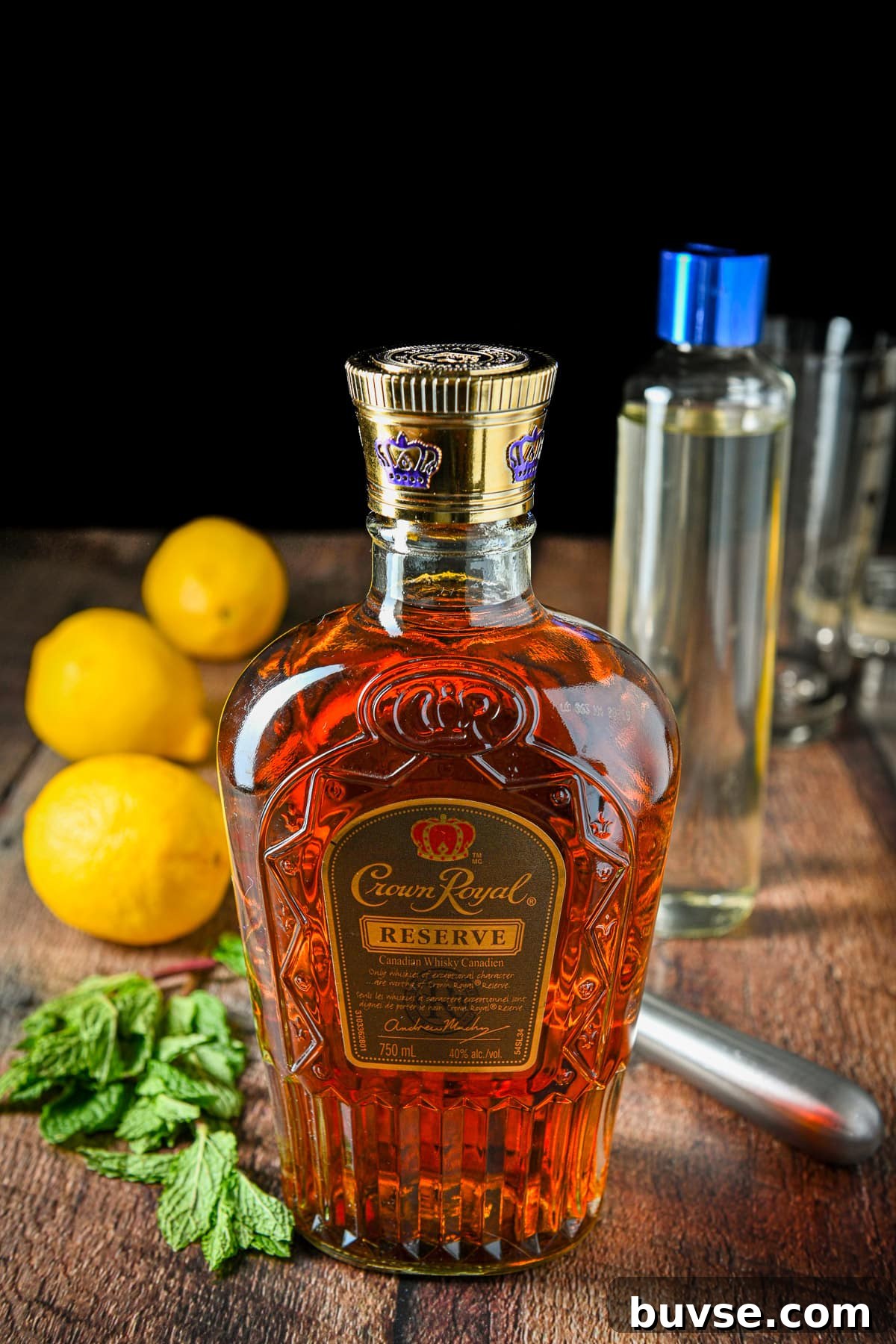 Whiskey, mint, lemon, and simple syrup on a table