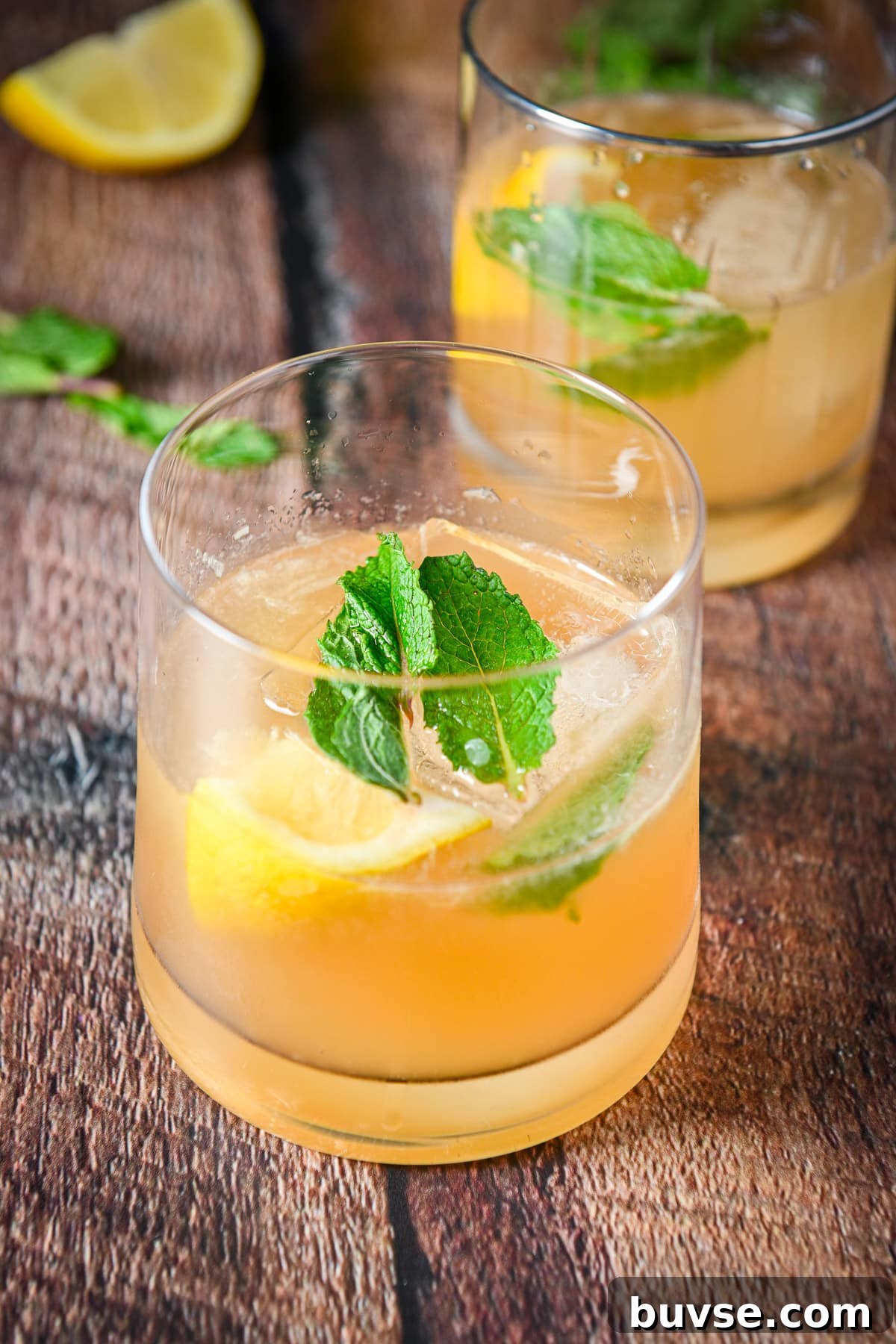 mint floating on the cocktail with whiskey and lemon
