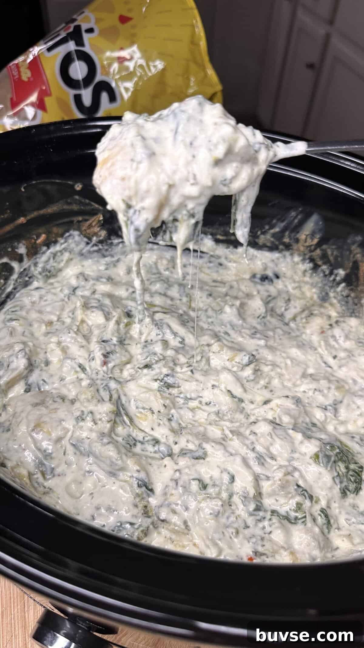 Crockpot spinach artichoke dip kept warm in a slow cooker