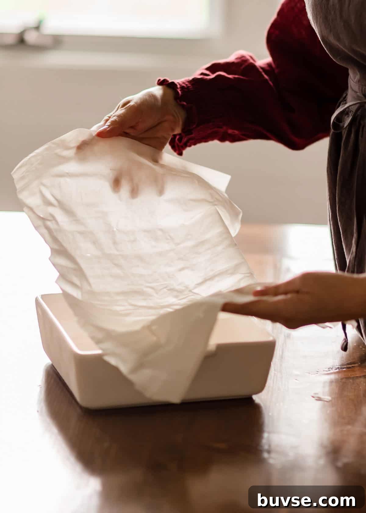 Phyllo Dough Recipes and Techniques 2 A woman placing phyllo dough sheet in a baking pan.