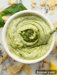 overhead shot of pesto mayo in white pot surround by garnish
