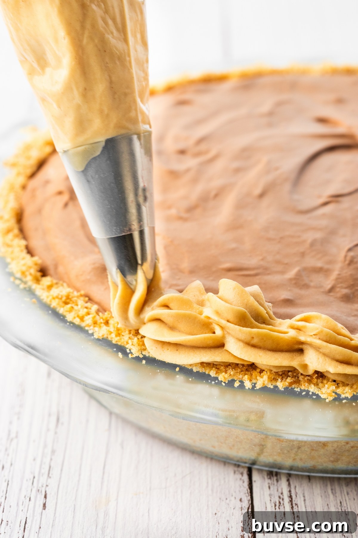 piping edging on peanut butter chocolate cream pie