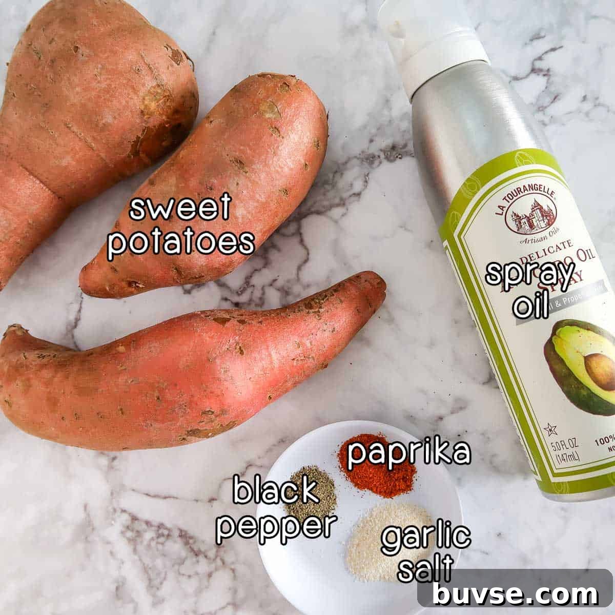 Overhead shot of ingredients - sweet potatoes, spray oil, black pepper, paprika, and garlic salt.