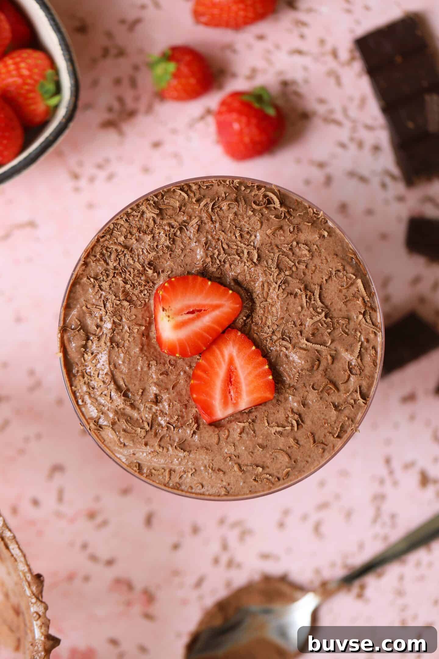 A bowl of protein chocolate mousse with strawberries on top.
