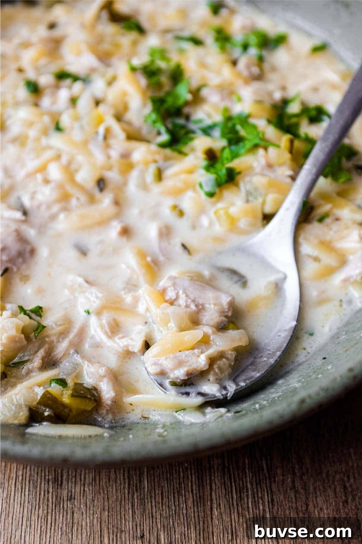 Greek Lemon Orzo Soup with Chicken | cookeatworld.com A bowl of Greek lemon orzo soup with chicken with a spoon