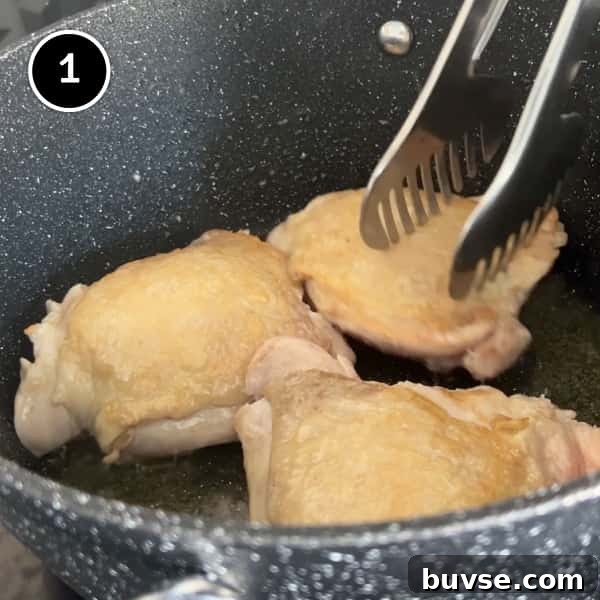 Greek Lemon Orzo Soup with Chicken | cookeatworld.com Growing the skin on three chicken thighs in a pan.