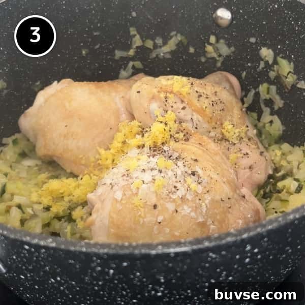 Greek Lemon Orzo Soup with Chicken | cookeatworld.com three chicken thighs on top of sautéed onion, zucchini and celery scattered with lemon zest, salt and pepper.