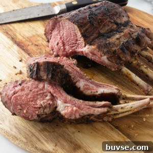 A grilled rack of lamb on a cutting board.