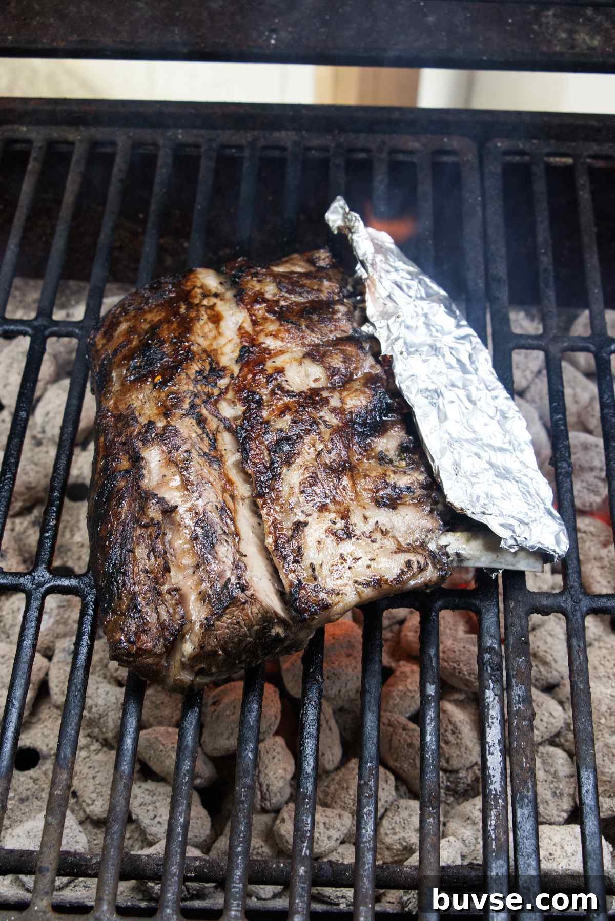 A rack of lamb on a grill over hot coals.