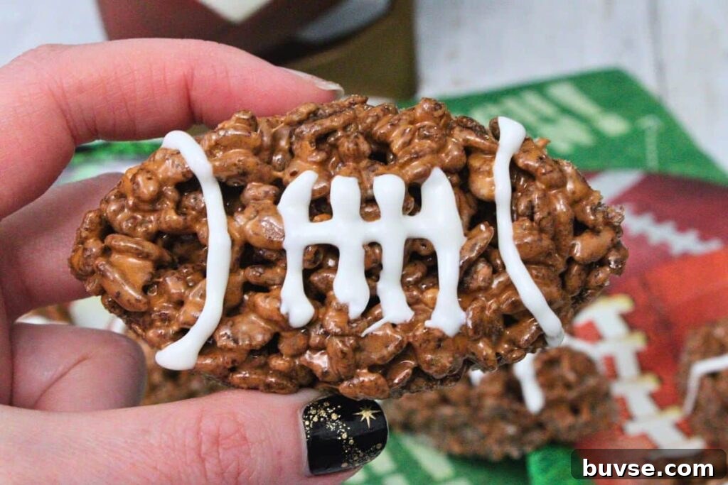 holding up a football rice krispie treat showing off icing laces