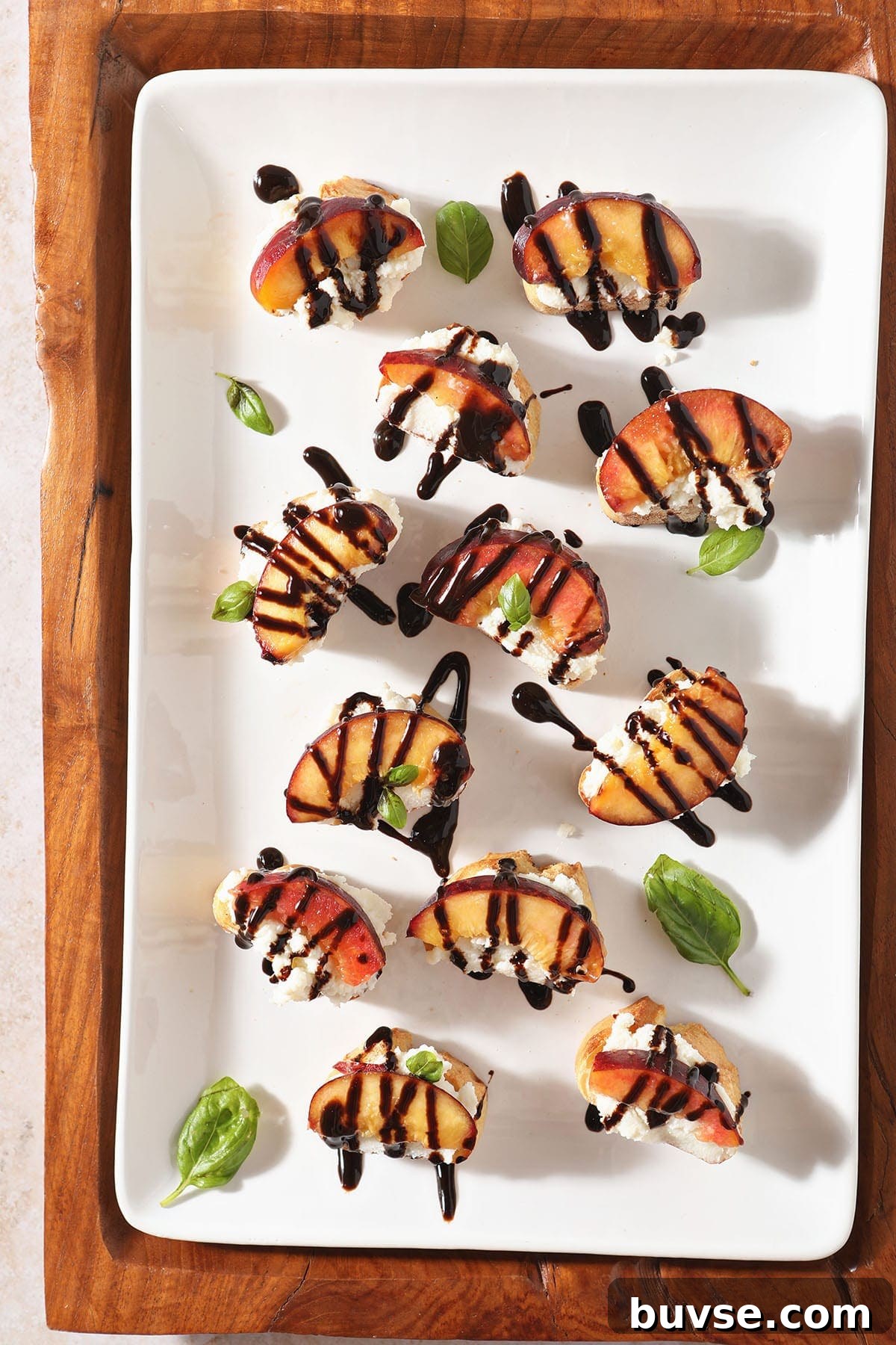 Summer Ricotta Crostini with Grilled Peaches 7 A white platter of several Ricotta Crostini with Grilled Peaches