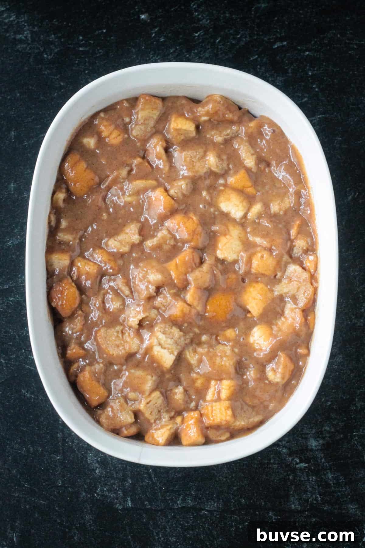Creamy Vegan Bread Pudding Recipe with Cinnamon 12 Bread and custard mixed in a baking dish.