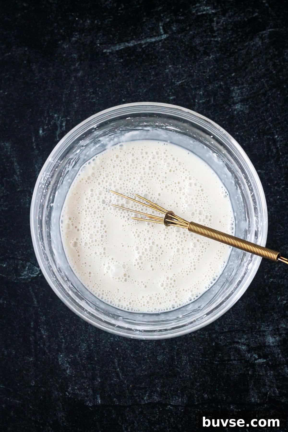 Creamy Vegan Bread Pudding Recipe with Cinnamon 4 Cornstarch and milk whisked together in a bowl.