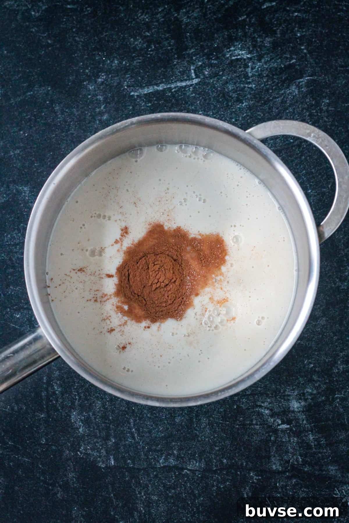 Creamy Vegan Bread Pudding Recipe with Cinnamon 5 Milk and spices in a sauce pot.