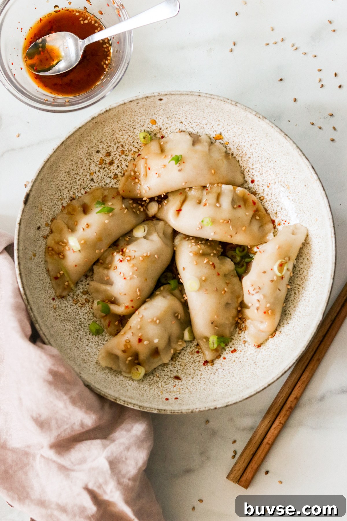 Korean dumplings, or mandu, on a plate drizzled with dipping sauce