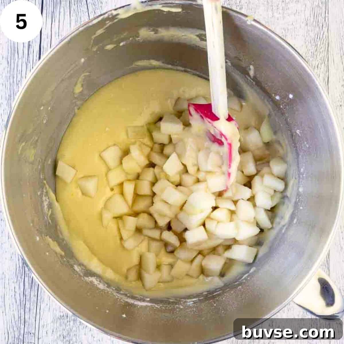 Adding diced pears to yellow batter.