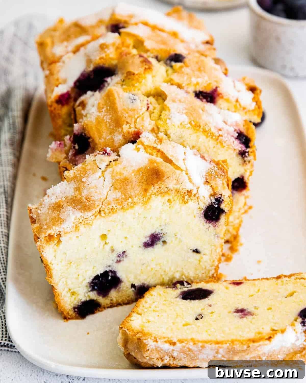 a sliced blueberry lemon pound cake on a plate.