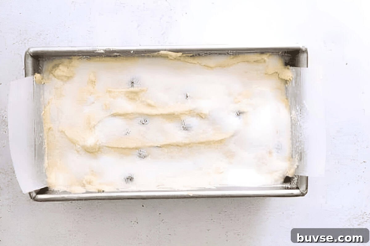 blueberry lemon pound cake batter in a cake pan topped with sugar.