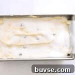 blueberry lemon pound cake batter in a cake pan topped with sugar.