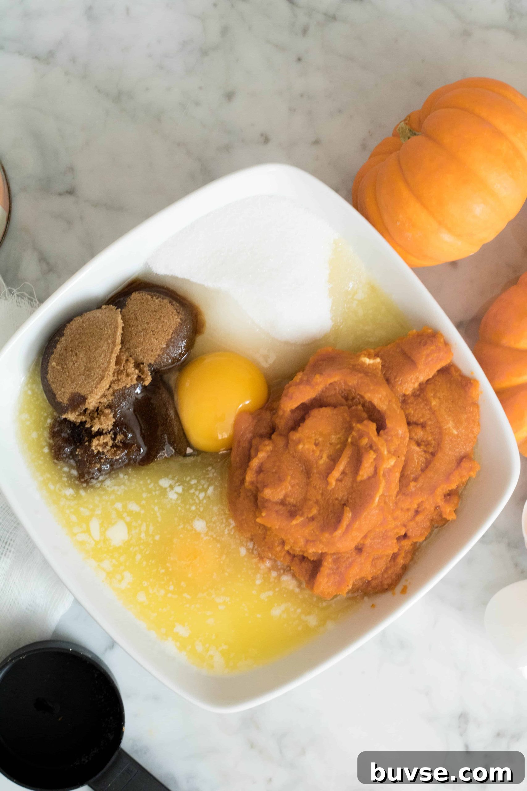 Eggs, pumpkin puree, brown sugar, regular sugar, and butter before mixing them to make the muffin batter