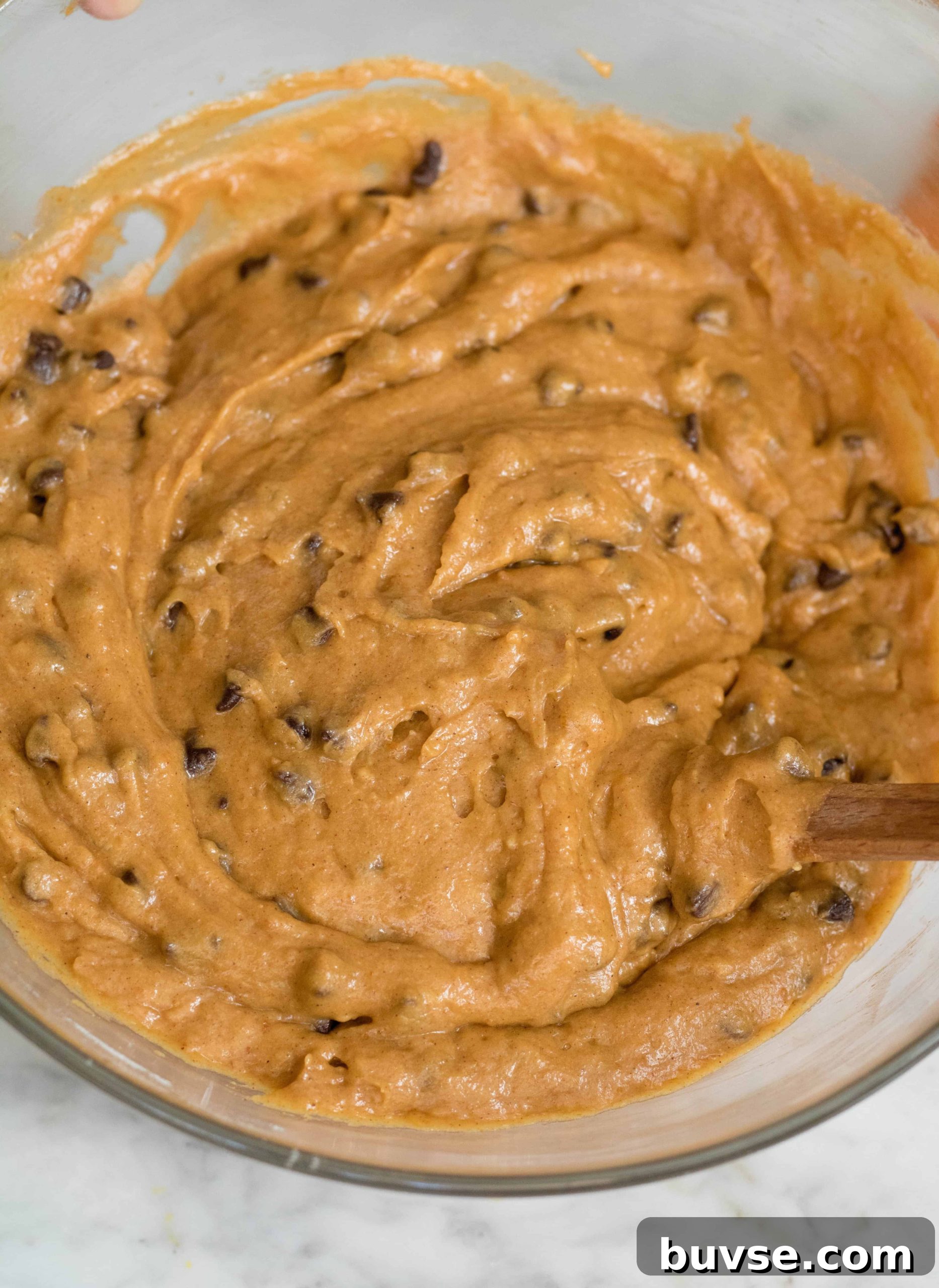 Orange mixed pumpkin muffin batter with mini chips