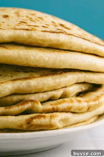 Close-up of Greek pita bread with soft layers and golden surface.