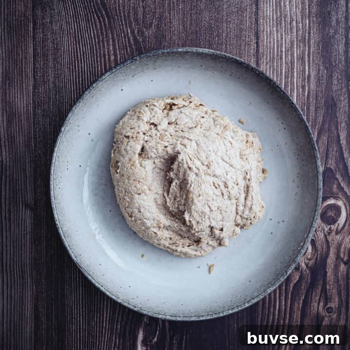 Gluten-Free Buckwheat Pita Bread Recipe 6 buckwheat pita dough mixed in a large ceramic bowl on a wooden surface.