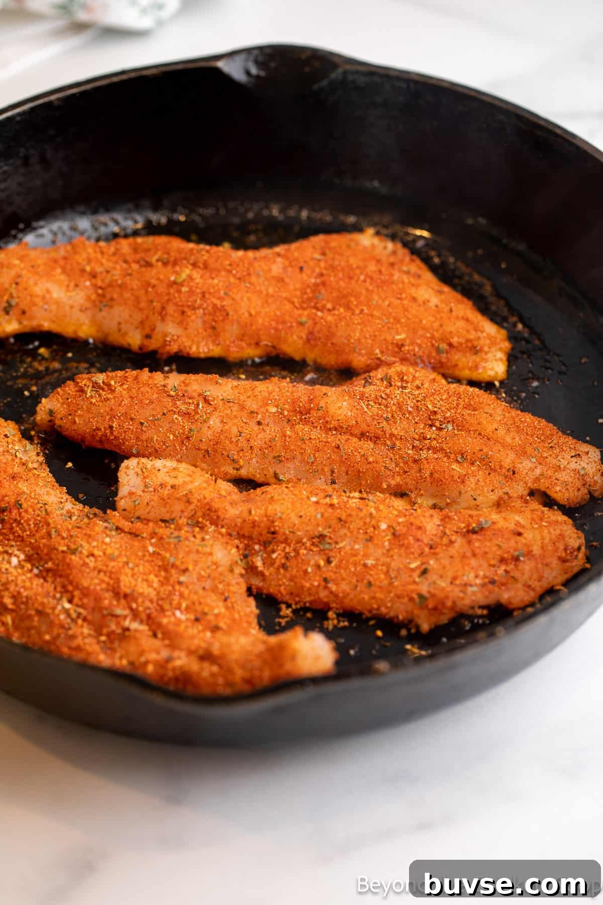 Cooking fillets in a cast iron skillet.