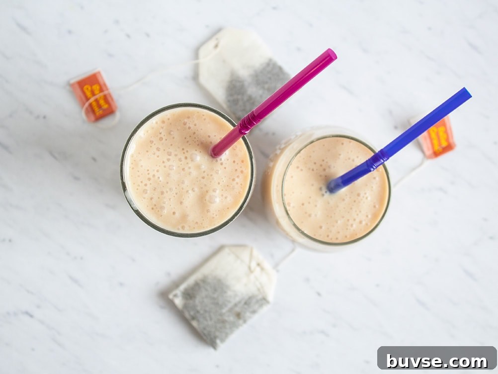 two glasses with keto smoothie inside with purple and blue straws sticking out