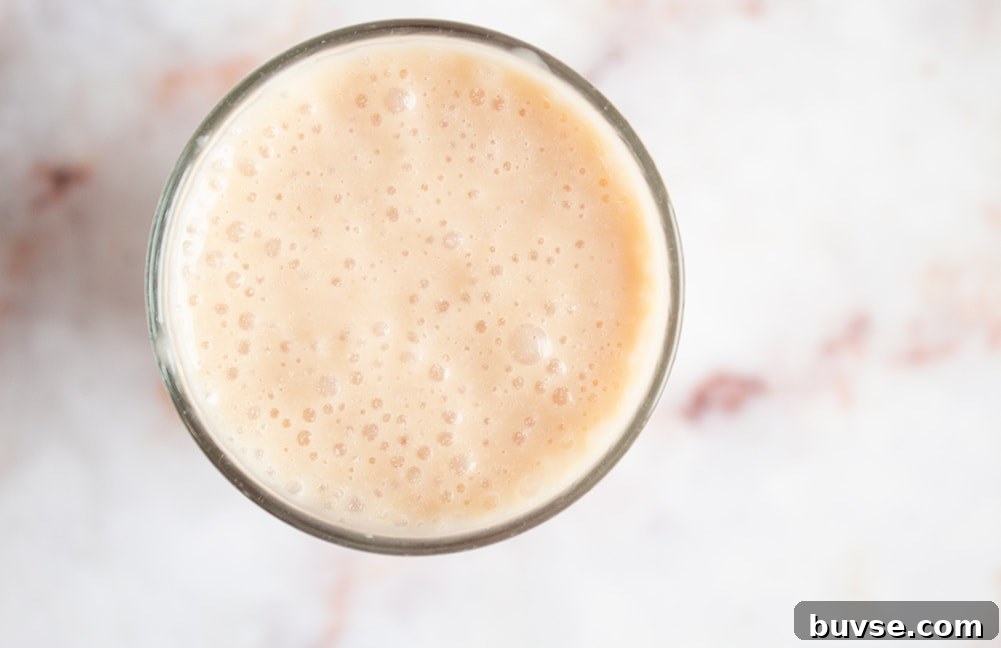salted caramel keto smoothie in a clear glass on countertop