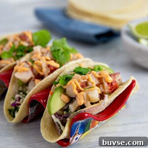 Closeup of Lobster Tacos with Cilantro Slaw set in a ceramic taco holder with Mexican art design on it