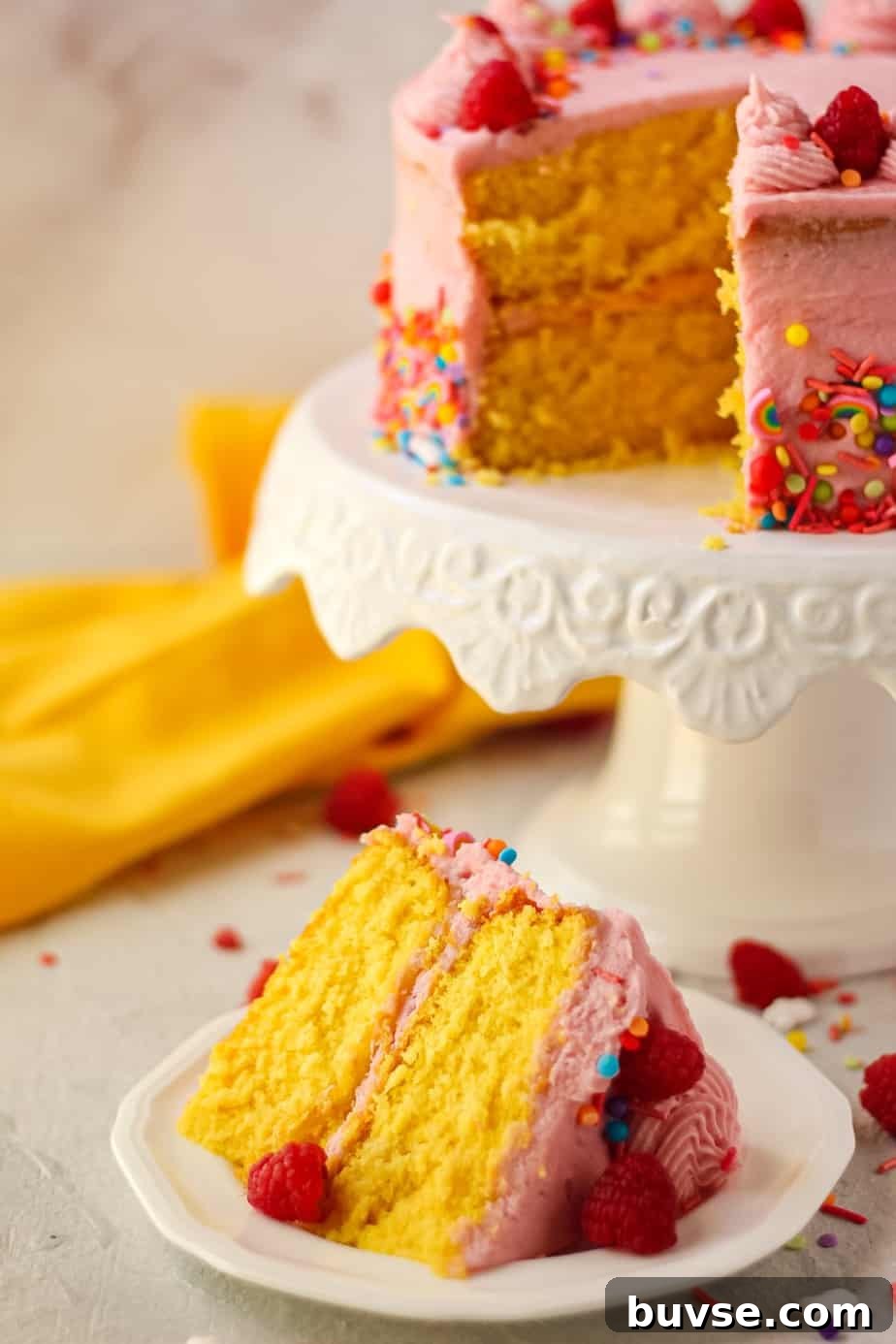 Lemon Raspberry Birthday Cake Recipe 3 side shot of sliced lemon raspberry birthday cake on white plate