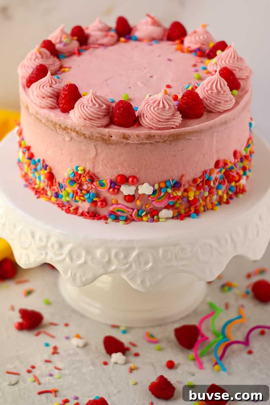 Lemon Raspberry Birthday Cake Recipe 4 side shot of lemon raspberry birthday cake on white cake stand