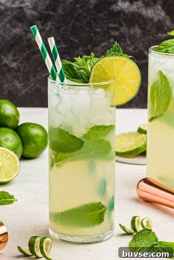Royal Peach Iced Tea Recipe 7 Bright yellow drink in a tall chilled glass, with two green striped straws.