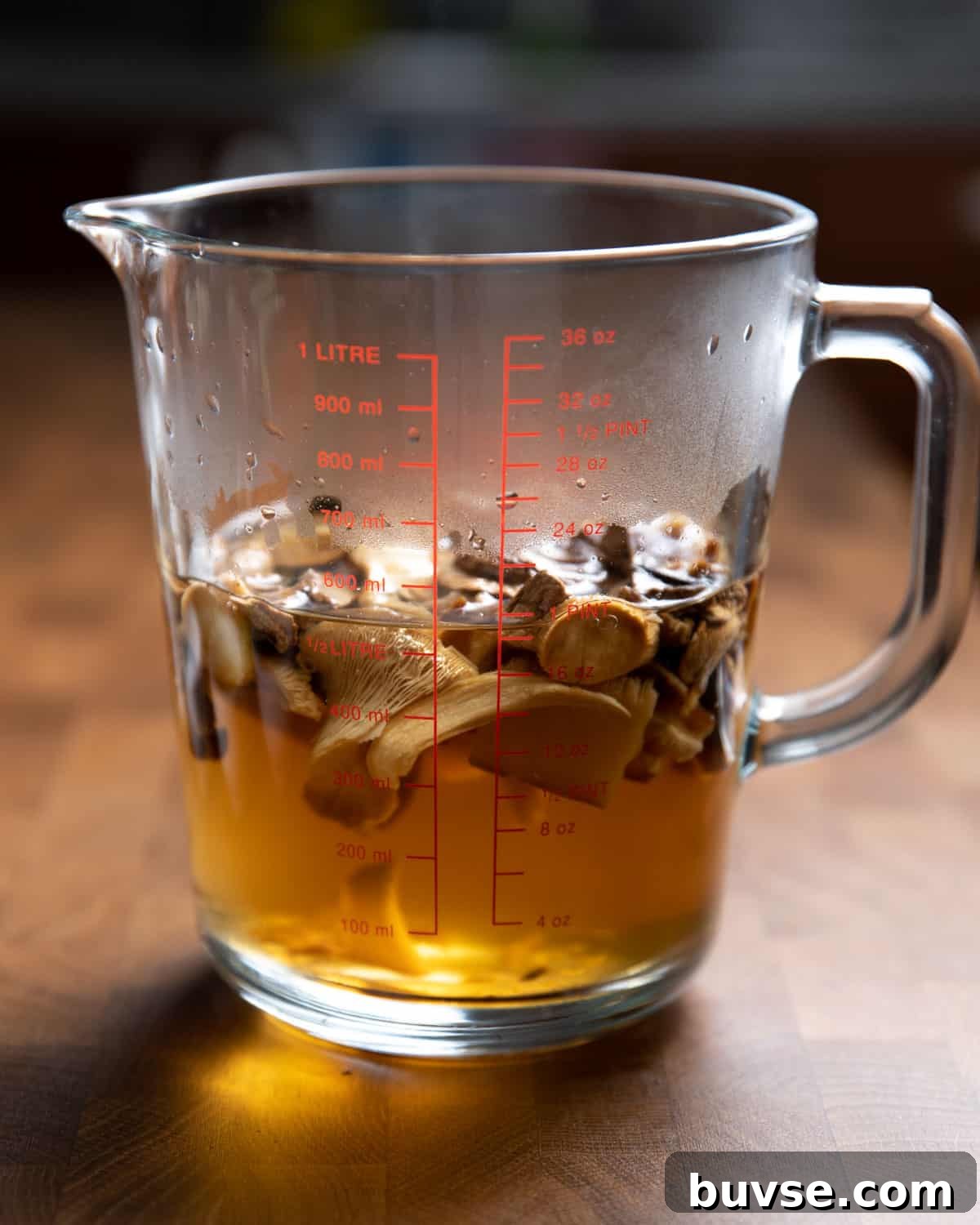 Photo of dried mushrooms re-hydrating in a jug of boiling water.