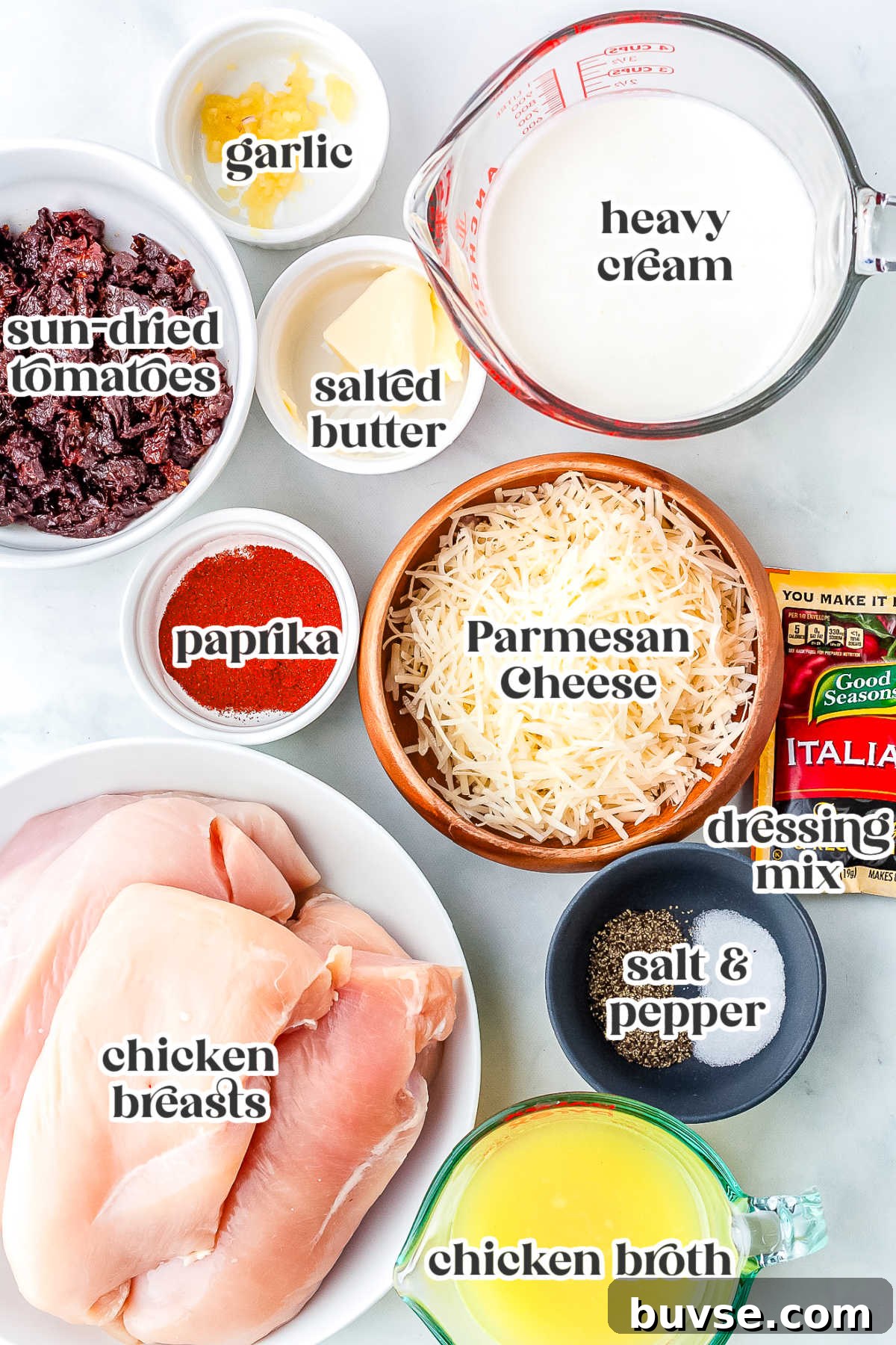 Ingredients for Crockpot Marry Me Chicken including chicken breasts, heavy cream, Parmesan cheese, sun-dried tomatoes, chicken broth, garlic, butter, Italian dressing mix, paprika, salt, and pepper.