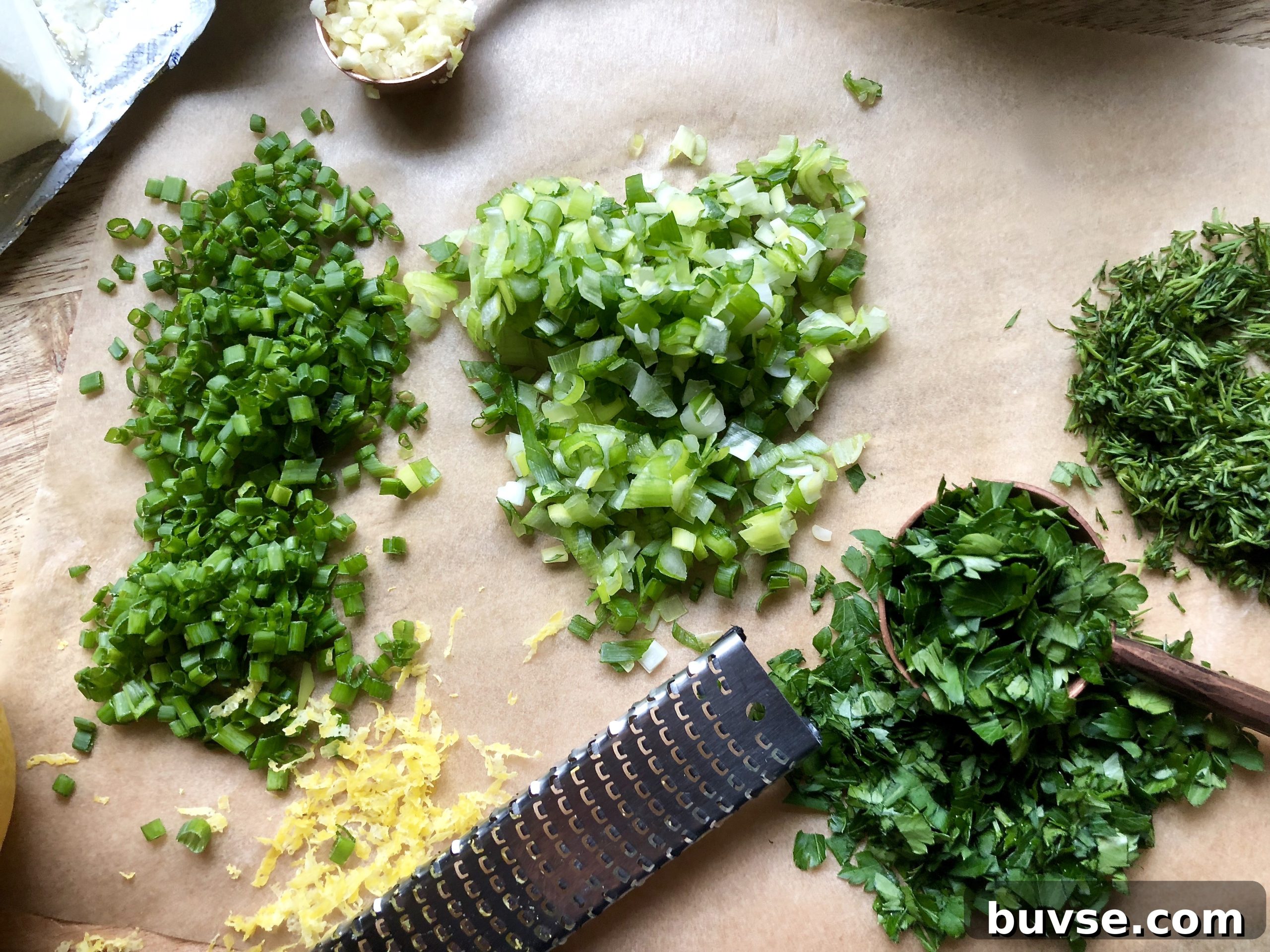 Herbs and lemon zest being mixed into dip