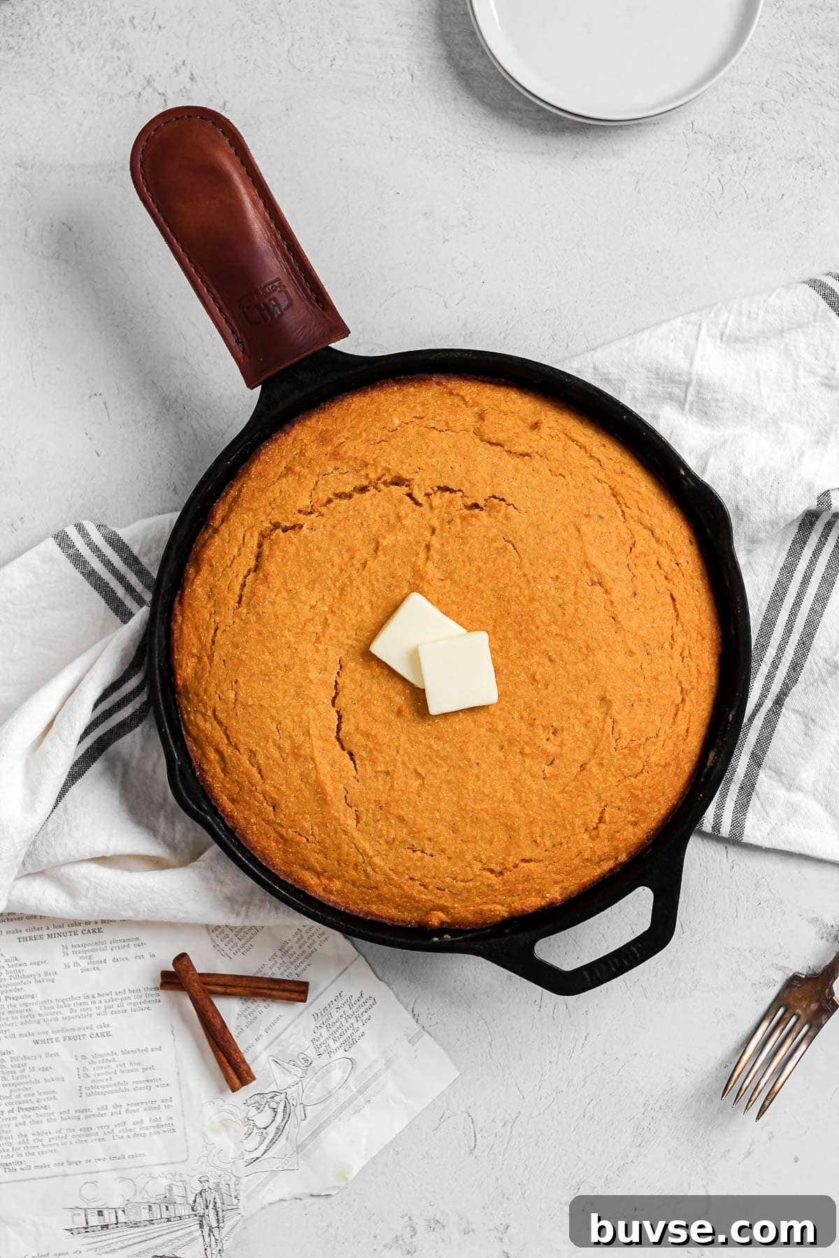 sweet potato cornbread in a cast iron skillet with butter