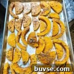 Slices of butternut squash on a baking sheet.